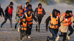 Inmigrantes con ni&ntilde;os corren hacia abarrotadas barcas en el norte de Francia
