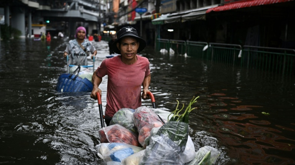  In kayaks or waist-deep in floodwater, shoppers return to Bangkok markets 